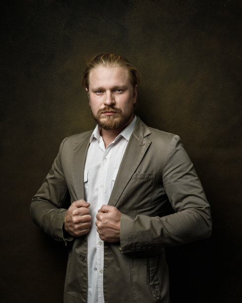 这是一幅英俊、残忍、强壮的男子的肖像，他看着镜头，双手紧握成拳头图片下载