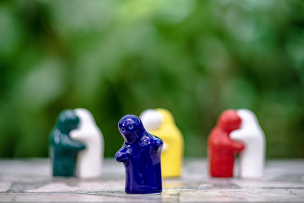 在绿色的自然背景和场景上的陶瓷娃娃，表现了孤独心中的爱。图片下载