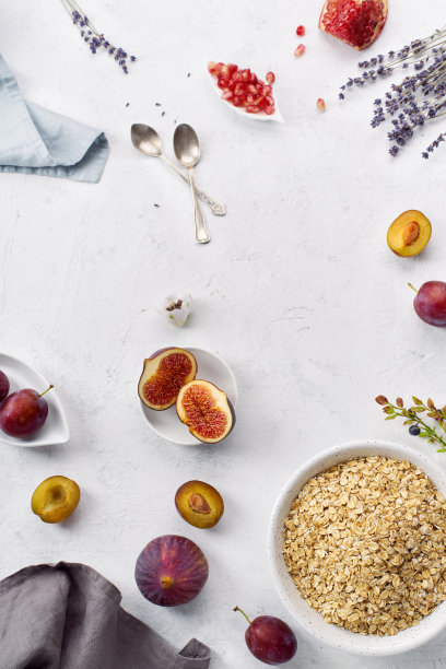 头顶拍摄的早餐生燕麦片与无花果，李子和石榴籽。创意平面与复制空间图片下载