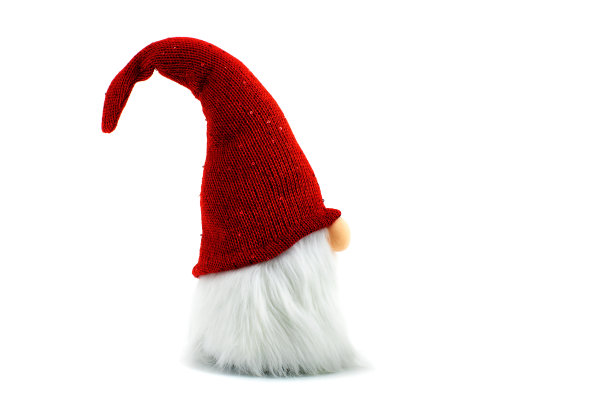 侏儒是一个圣诞小精灵，戴着一顶大红色的闪闪发光的帽子，站在白色的背景上图片下载