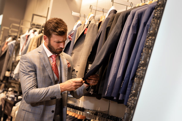 优雅的男子在服装店看报关图片下载