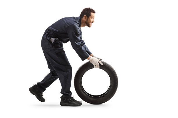 修理工在滚动汽车轮胎图片下载