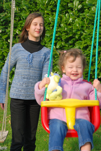 一个女孩和她的妹妹在荡秋千图片下载