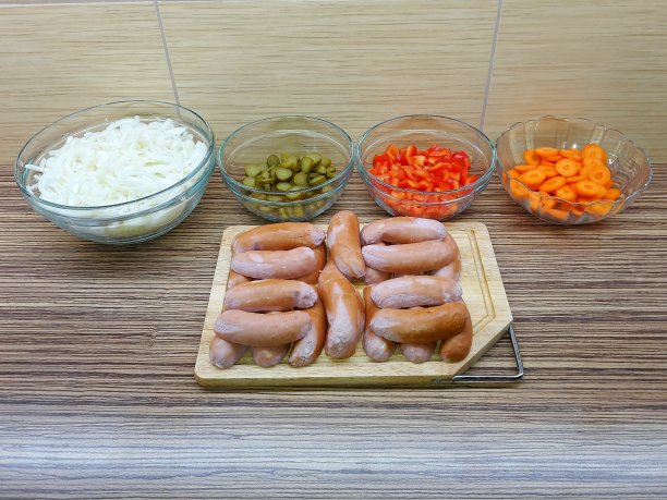 腌香肠的配料是洋葱、黄瓜、胡椒和胡萝卜，放在砧板上和玻璃碗里图片下载