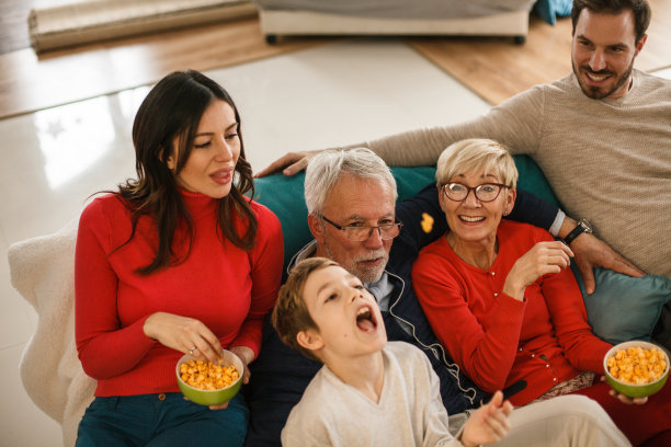 和家人一起看电视的时候，扔零食和吃零食来取乐图片下载