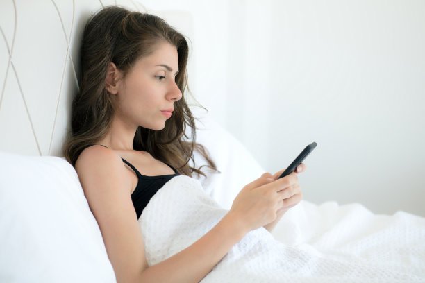 女人在床上用手机图片下载