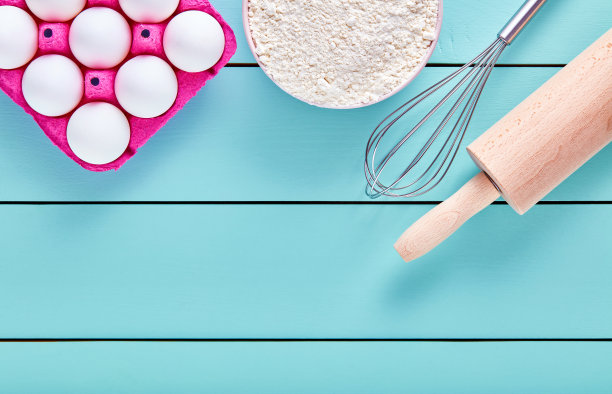 烘焙原料，鸡蛋，面粉，打蛋器和蓝底擀面杖图片下载