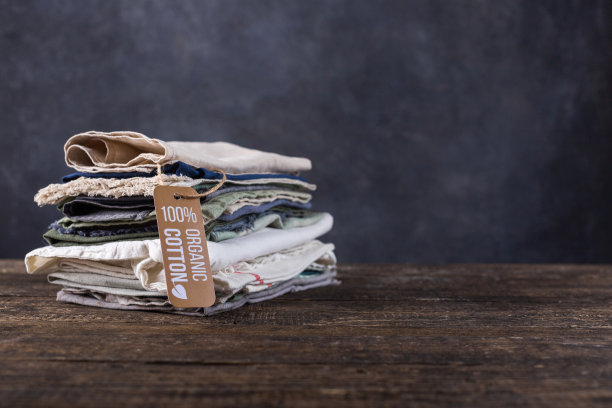 木桌上放着一堆东西。色彩柔和的棉布，亚麻布衬衫，碎布，披肩图片下载