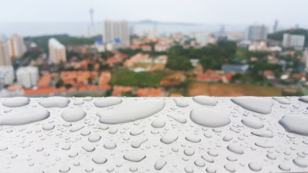 水滴的背景在灰色光泽的表面俯瞰城市，雨滴的灰色纹理为化妆品，饮料产品。图片下载