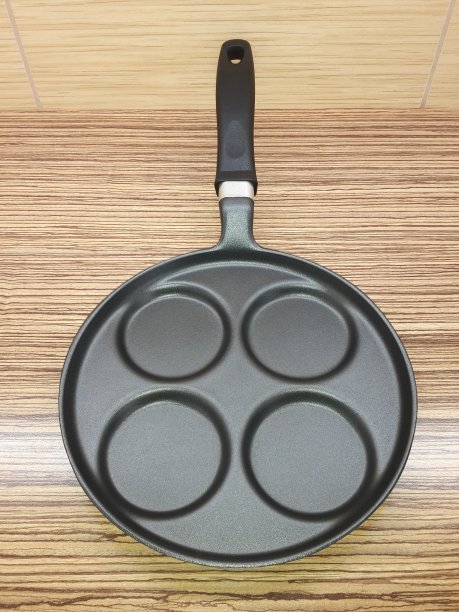 煎四个鸡蛋或煎饼的平底锅，带柄，放在厨房台面上图片下载