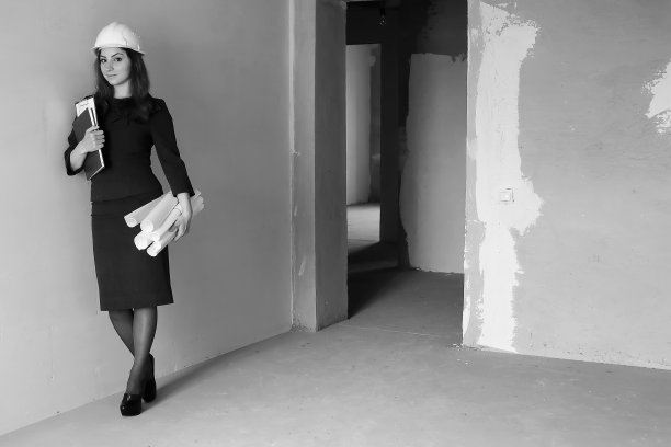 一名女建筑师在工地上的黑白照片，带着图纸和笔记本图片下载