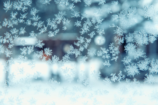 冬天透过结冰的窗户看到的院子里的雪花和白霜。圣诞节和冬天的时间概念图片下载