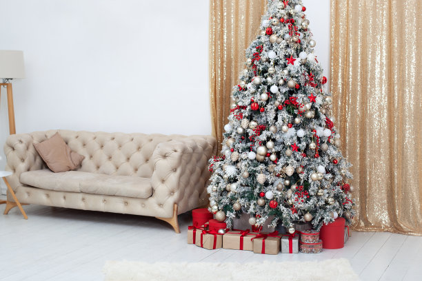 新年。圣诞快乐，节日快乐。时尚的客厅内部装饰圣诞树和舒适的沙发。圣诞树和许多礼物在家里。新年室内装饰室。图片下载