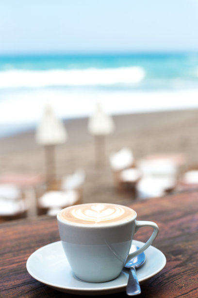 木桌背景上放着一杯热卡布奇诺。图片下载