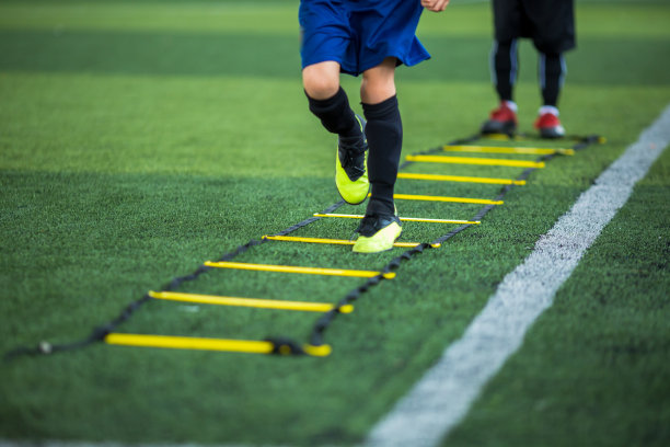 孩子足球运动员慢跑和跳跃之间的梯子训练足球训练。图片下载