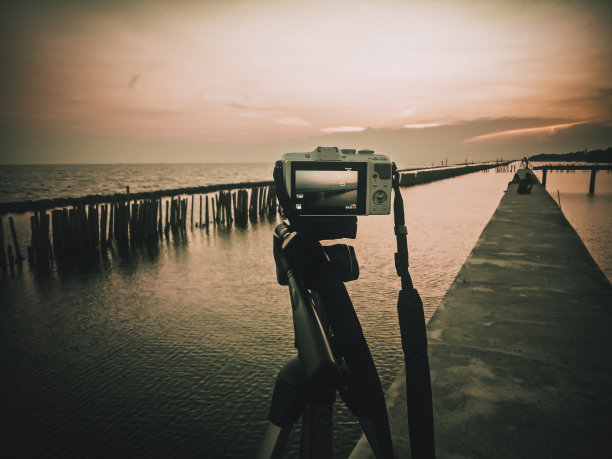 三脚架上的相机。在日落时拍下美丽的瞬间图片下载