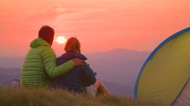 近景:露营者和他们的狗享受一个轻松的晚上在山。图片下载