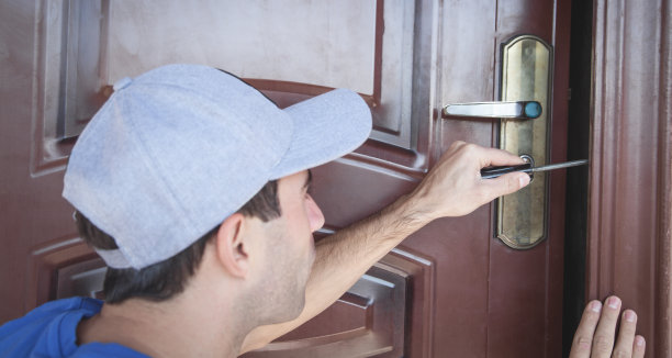 熟练使用螺丝刀修理门锁。图片下载