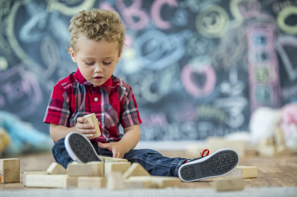 年轻的卷发学步儿童玩积木股票照片图片下载