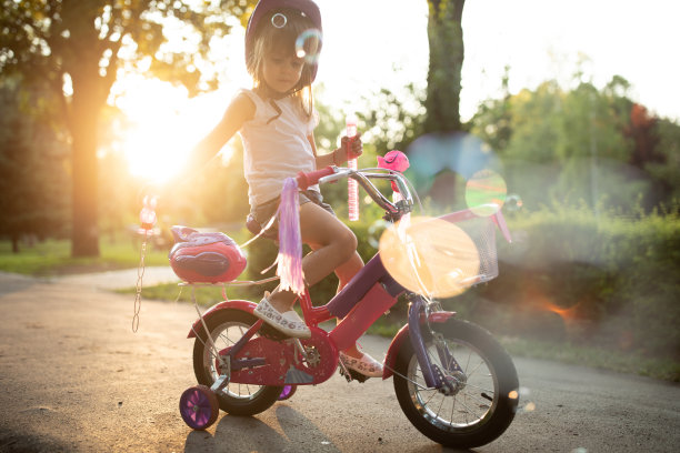 骑自行车的女孩在公园里吹泡泡图片下载