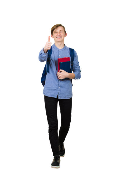 全身像的快乐的学生男孩去学校拿着两本书和显示拇指向上的手势。快乐的青少年行走与积极的面部表情孤立在白色的背景。图片下载