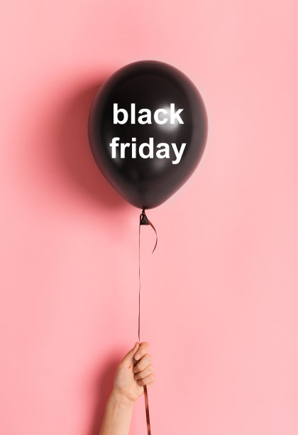 黑色星期五气球在女人的手在粉红色的背景图片下载