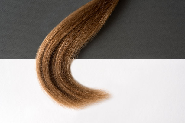 黑白背景上的一缕金发。美丽的概念。空间的文本图片下载