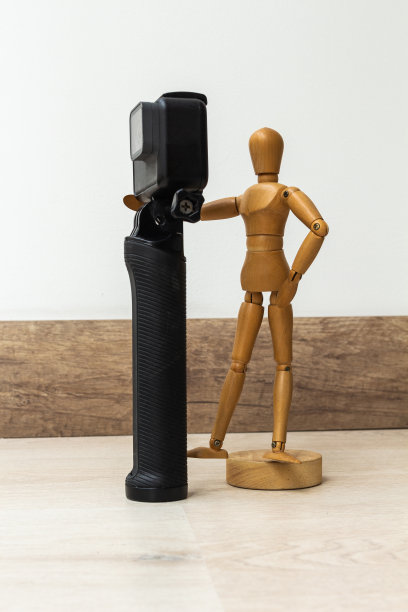木制假人，配有照片和摄像机，木地板和白色背景图片下载