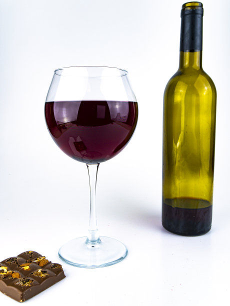 白色背景上的红酒和巧克力。图片下载
