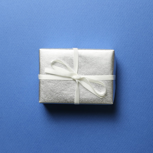 蓝色背景的银色礼盒。圣诞节或生日概念图片下载