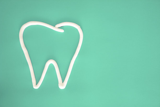 手绘牙齿符号与牙膏在绿色背景图片下载