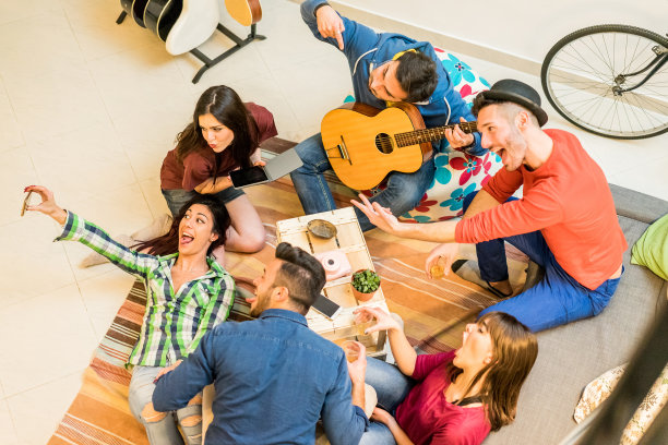 时尚的朋友有乐趣在宿舍在派对之夜自拍-快乐旅行的人享受时间一起玩音乐-友谊，夜生活和青年概念-主要集中在左边的女孩的脸图片下载