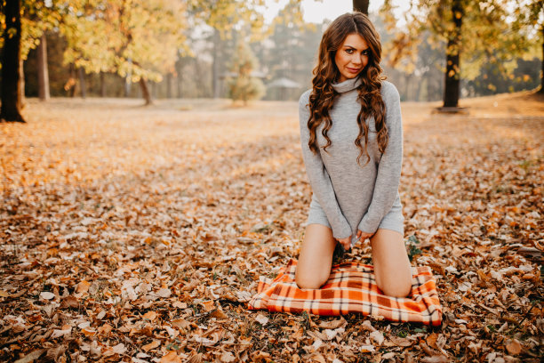 性感性感的年轻女性在森林里摆姿势的秋天的树叶图片下载