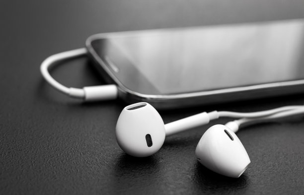 耳机与智能手机在黑色。关闭了。图片下载