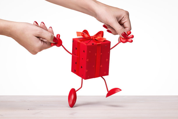 礼物。盒子用红纸包装，用丝带和蝴蝶结装饰。图片下载