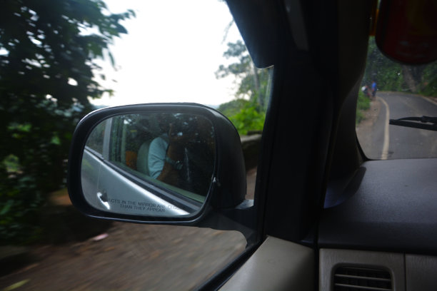 近距离观察一辆汽车在运动从前座与反射的汽车的后视图图片下载