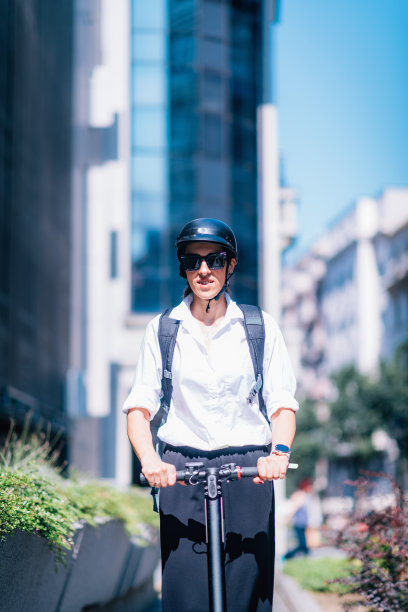 骑着摩托车的女人在街上。图片下载