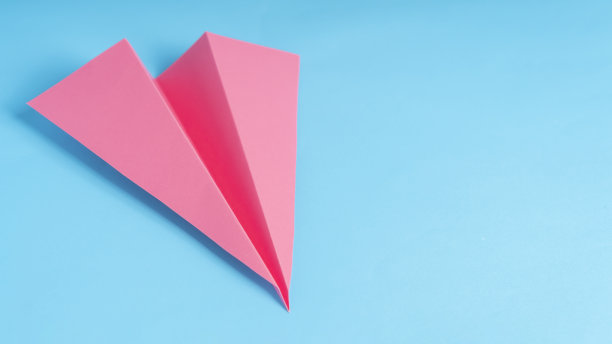 蓝色背景下的粉色纸飞机图片下载