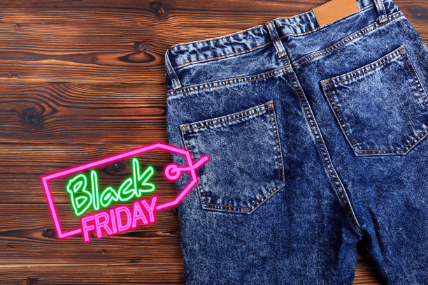 木制背景上的蓝色粗斜纹棉布牛仔裤。黑色星期五大减价-图片图片下载