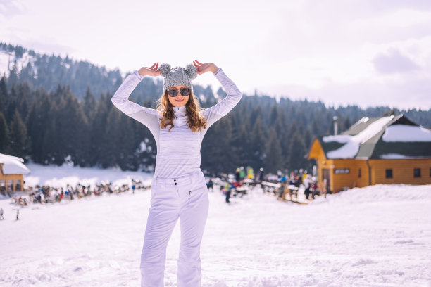 女孩戴着可爱的帽子站在雪地里图片下载