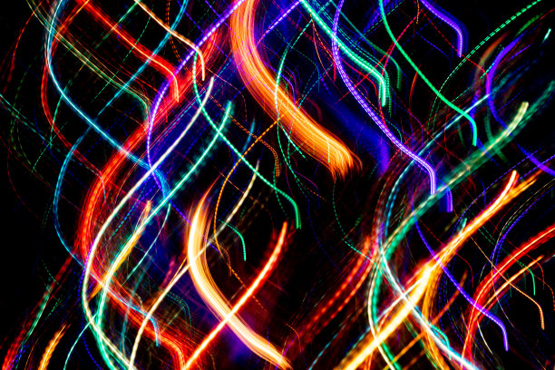 近景抽象背景的彩色混沌发光的霓虹灯波浪条纹上的黑色。图片下载