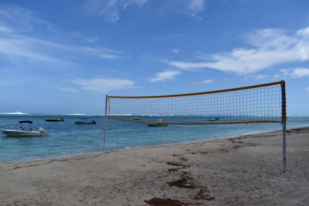 图片的热带海滩与美丽的颜色，休闲船的背景和排球网休闲或一些体育活动图片下载