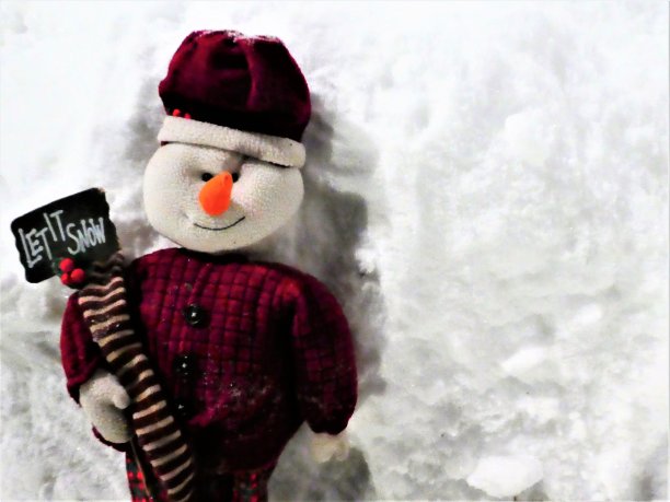 圣诞雪人与一个让它下雪的标志在一个白色的雪的背景图片下载