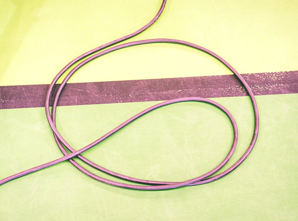 黑色插头插在抛光的绿色地板上图片下载