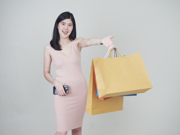 肖像的购物妇女与彩色购物袋购物者在白色的背景。图片下载