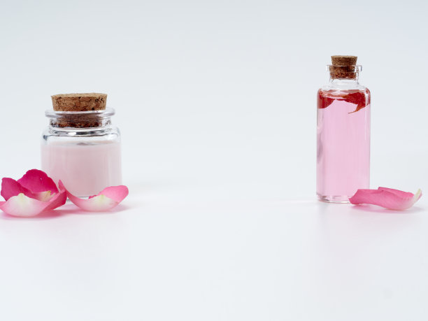 天然化妆品与玫瑰油和乳液在白色的背景。图片下载