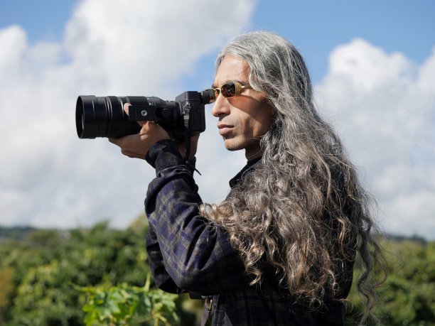 摄影师使用现代无反光镜相机在自然中拍照图片下载