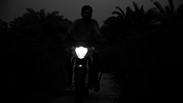 年轻人在晚上骑着自行车的独特照片图片下载