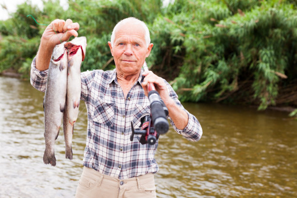 渔夫在河边与猎物摆姿势图片下载