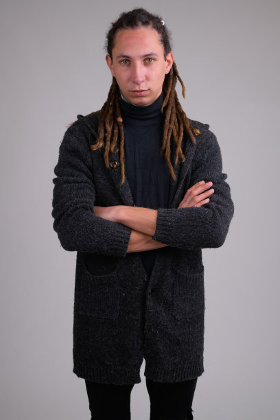 年轻英俊的男子的肖像，长发绺交叉着胳膊图片下载